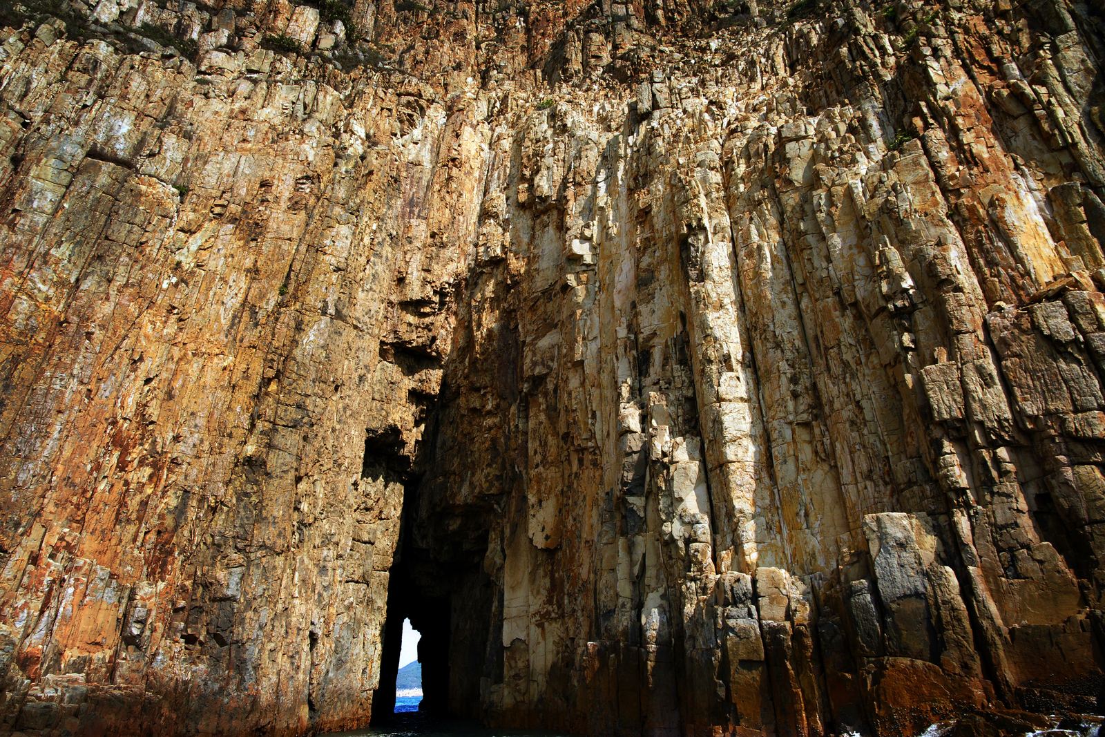 Columnar-jointed volcanic rock rising above the sea in Hong Kong