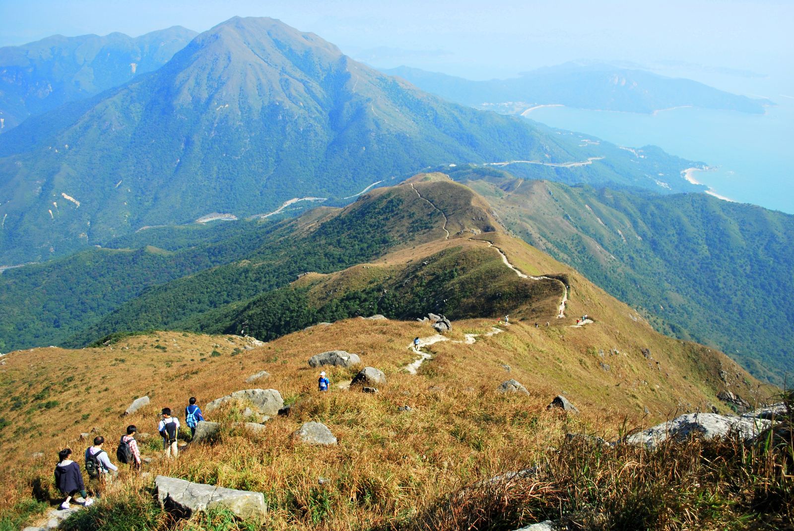 Members walking a ridge trail high above Hong Kong's coastline